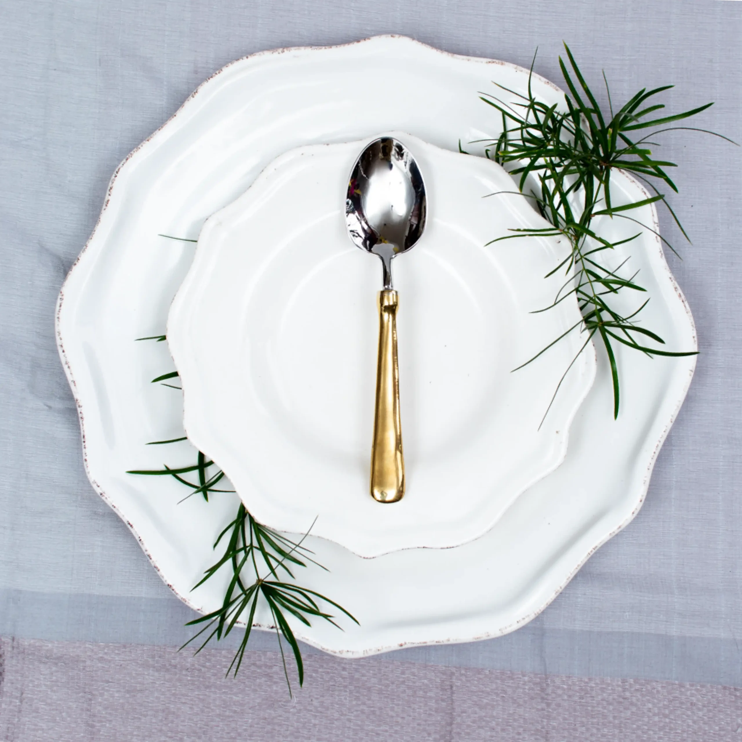 Handcrafted stainless steel teaspoon with brass handle on white ceramic plate, made in Pilimathalawa Kandy Sri Lanka