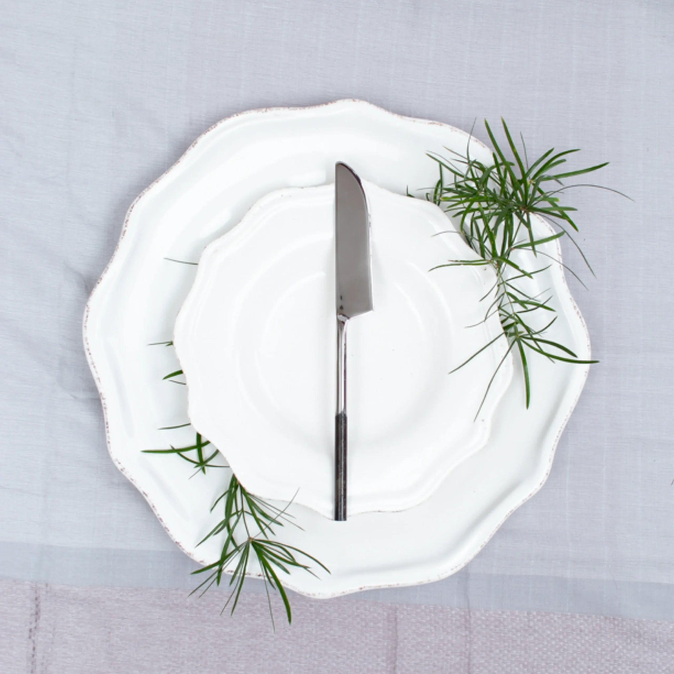 Handcrafted stainless steel table knife with black handle on white ceramic plate, made in Pilimathalawa Kandy Sri Lanka