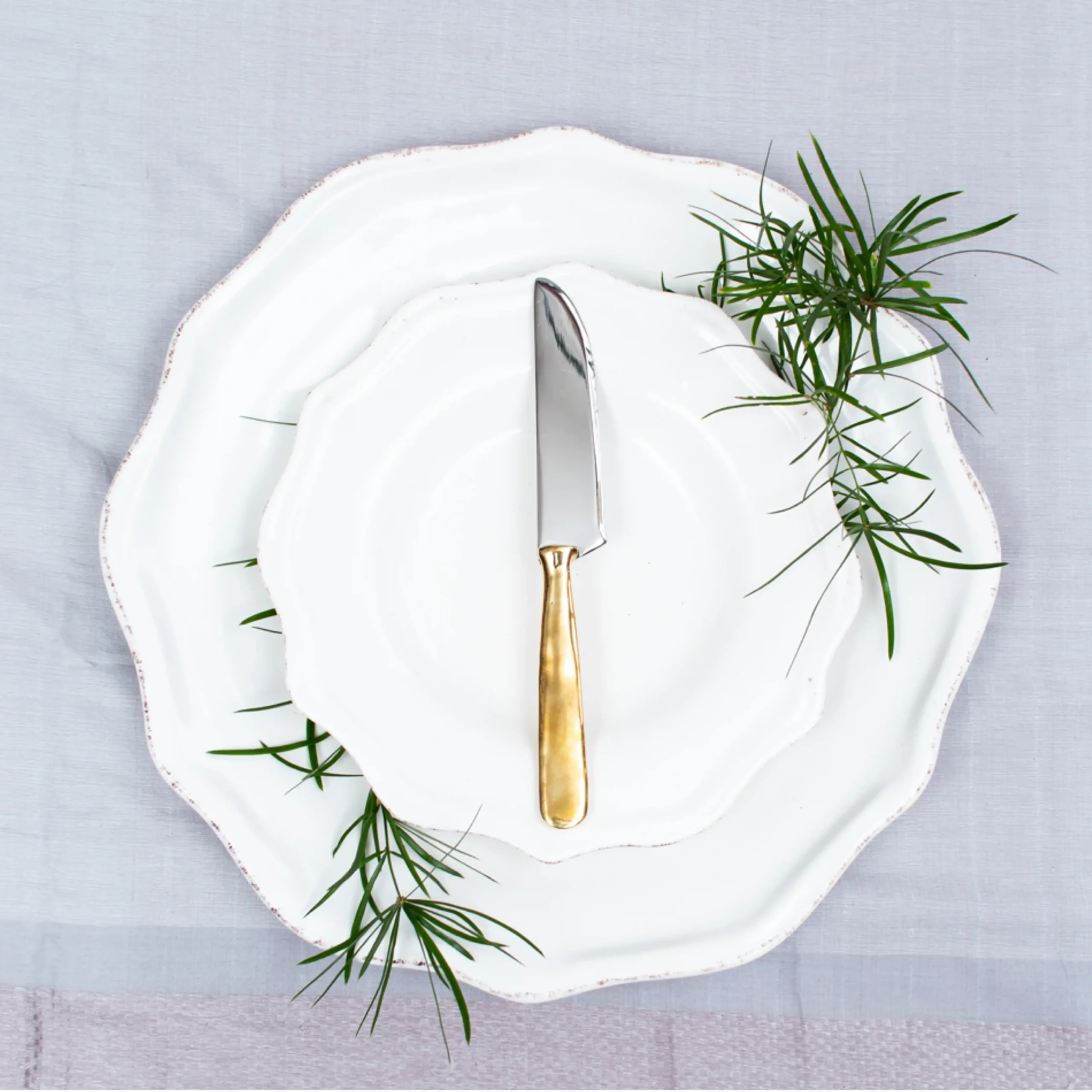 Handcrafted table knife with brass handle on white ceramic plate, made in Kandy Sri Lanka