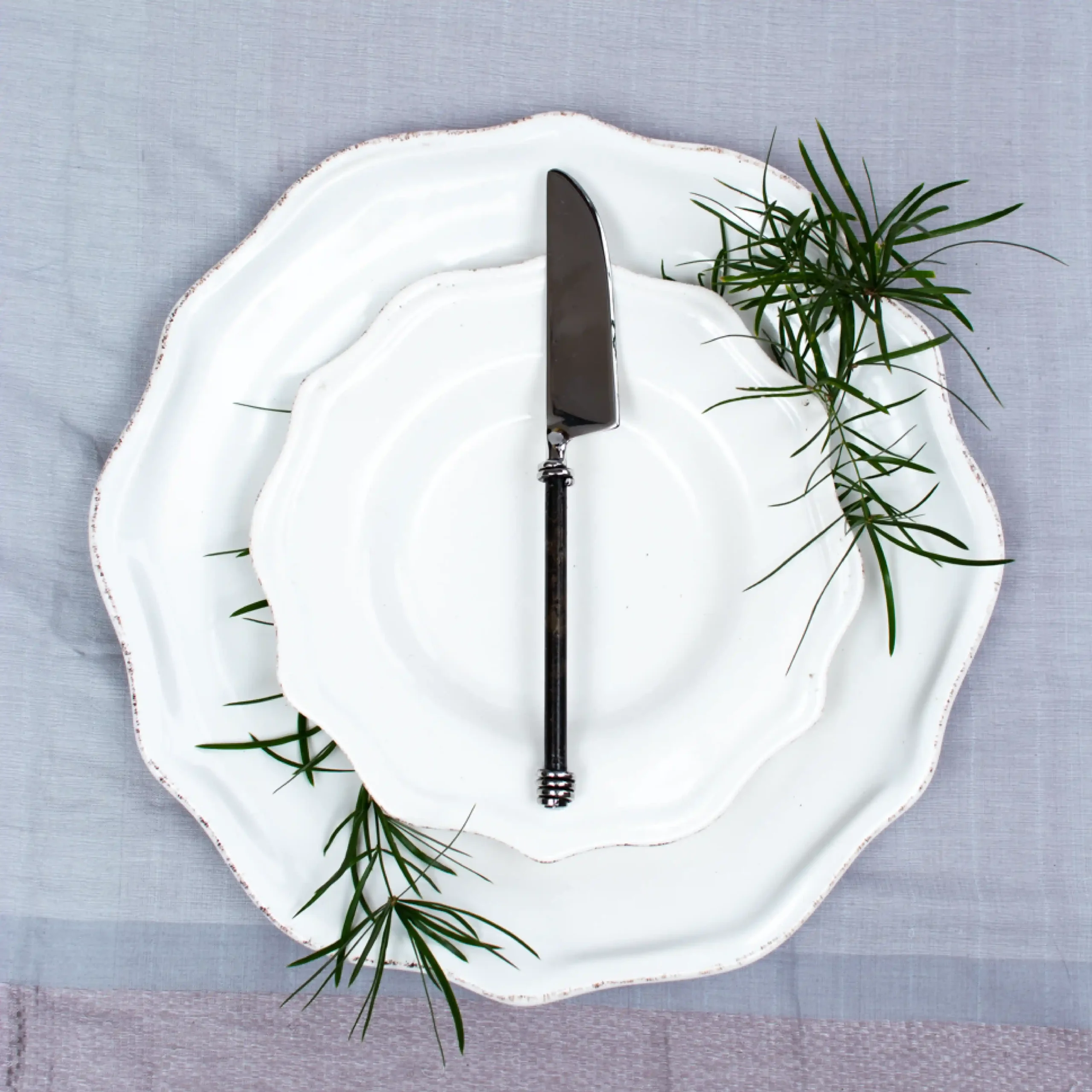 Handcrafted table knife with black handle and silver collar on white ceramic plate, made in Kandy Sri Lanka